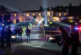 Police officers outside of a large house at night