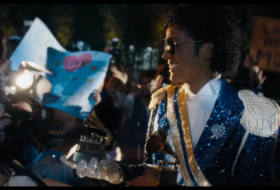 Still from the film "Michael" of Michael Jackson holding a grammy with paparazzi