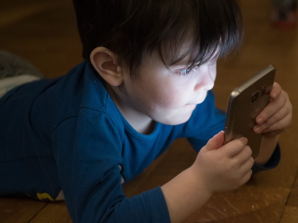 young boy holding up a smartphone to his face