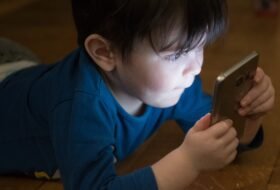 young boy holding up a smartphone to his face