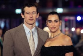Dua Lipa and Callum Turner posing for the camera at an event