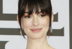 Anne Hathaway smiling for the cameras on the red carpet